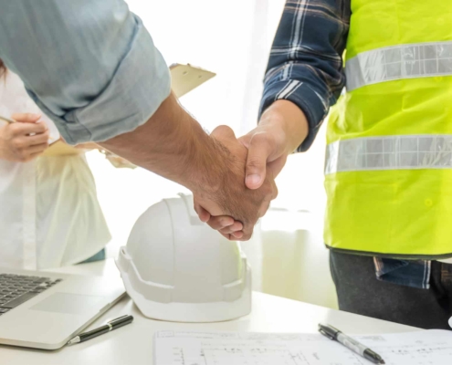 Side view of two people shaking hands after signing a contract