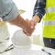 Side view of two people shaking hands after signing a contract