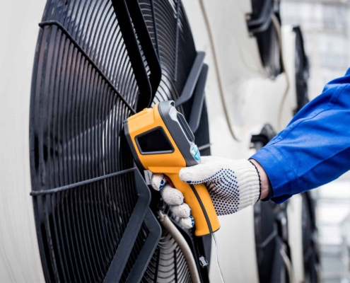 Technician uses a thermal imaging infrared thermometer to check the condensing unit heat exchanger