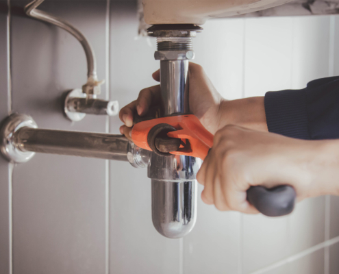 Plumber at work in a bathroom, plumbing repair service